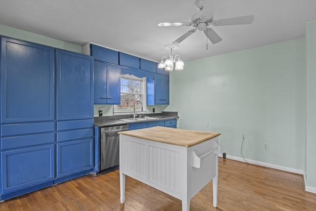 kitchen featuring blue cabinetry, wood finished floors, a sink, ceiling fan with notable chandelier, and stainless steel dishwasher