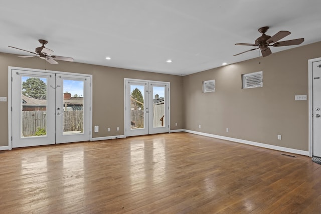 unfurnished living room with baseboards, wood finished floors, french doors, and a ceiling fan