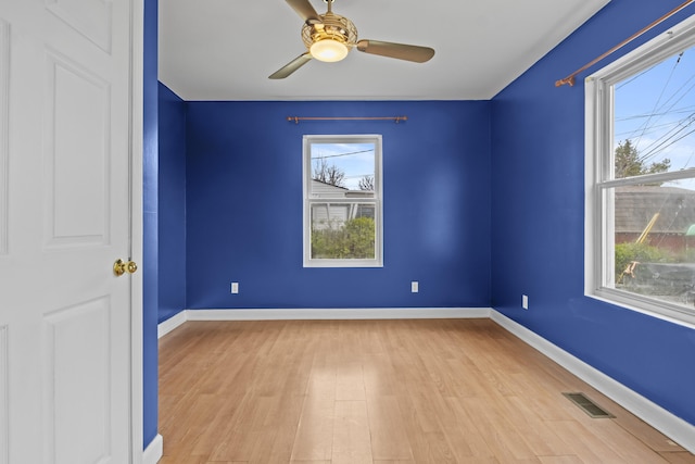 unfurnished room with a wealth of natural light, baseboards, and visible vents