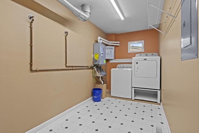washroom featuring baseboards, washing machine and clothes dryer, tile patterned floors, tankless water heater, and laundry area
