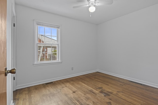 empty room with hardwood / wood-style flooring, baseboards, ceiling fan, and visible vents