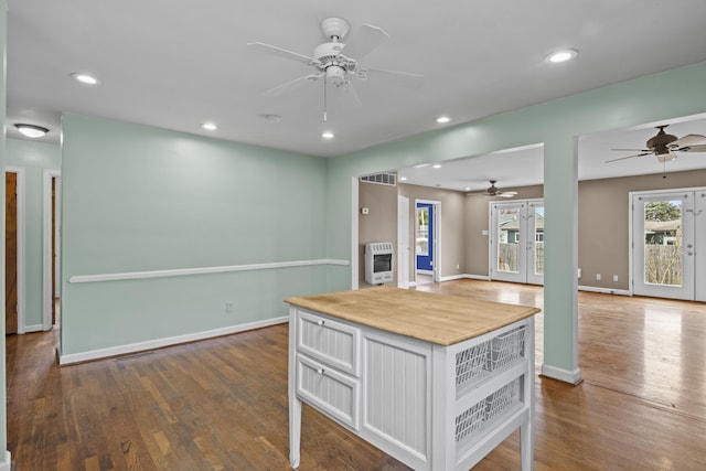 kitchen with heating unit, ceiling fan, wood finished floors, and open floor plan