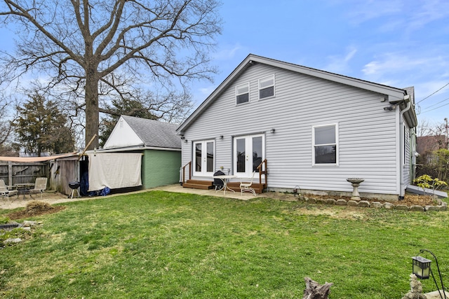 back of house with fence, entry steps, a patio, a lawn, and french doors