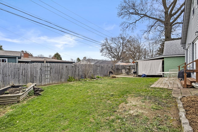 view of yard with a fenced backyard, a vegetable garden, and a patio