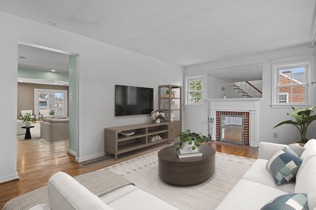 living area featuring baseboards, a fireplace, and wood finished floors