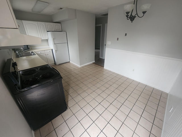 kitchen featuring light countertops, a sink, freestanding refrigerator, exhaust hood, and visible vents