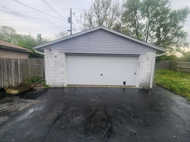 detached garage featuring fence