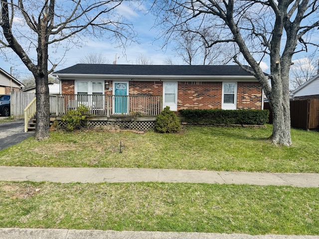 ranch-style house with brick siding, fence, and a front lawn