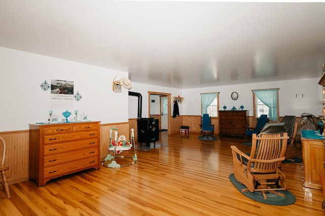 4241 Kendall Springs Rd, Owingsville, KY 40360 - sitting room featuring wood walls, a wood stove, light wood finished floors, and wainscoting