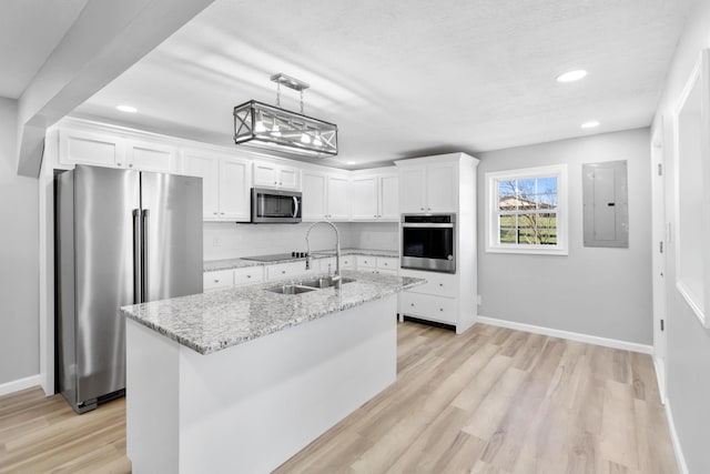 kitchen with electric panel, light wood-style flooring, white cabinetry, appliances with stainless steel finishes, and a sink