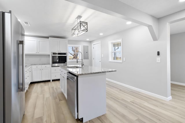 kitchen featuring light wood-type flooring, a sink, visible vents, and stainless steel appliances