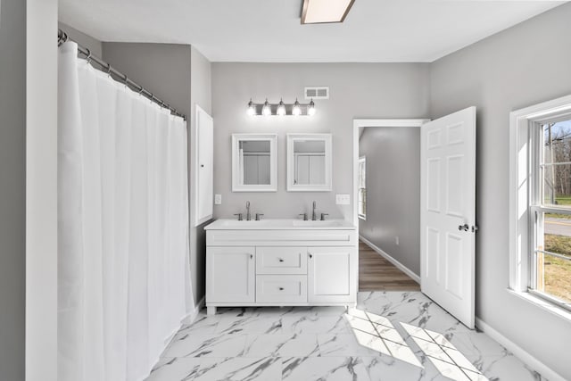 bathroom featuring double vanity, visible vents, marble finish floor, and a sink