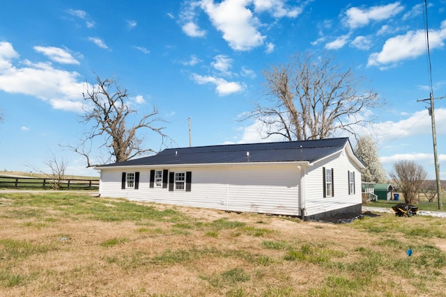 back of house with a yard, metal roof, and fence