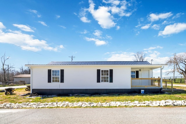 view of side of home with a porch and metal roof