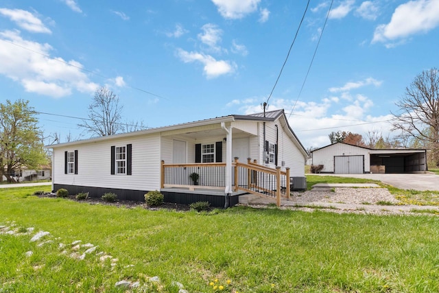 view of front of property featuring a front yard, central AC unit, a porch, a garage, and an outbuilding