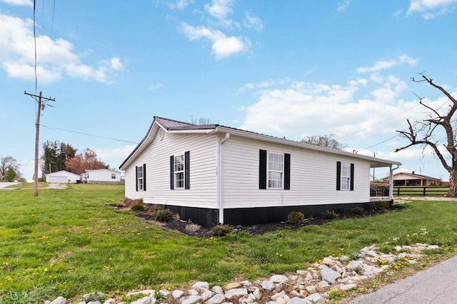 view of side of property with a lawn