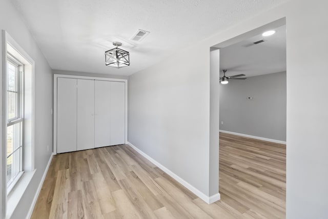 interior space with light wood finished floors, visible vents, and baseboards
