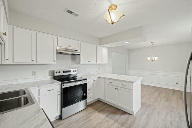 kitchen featuring stainless steel electric range, under cabinet range hood, a chandelier, visible vents, and a peninsula