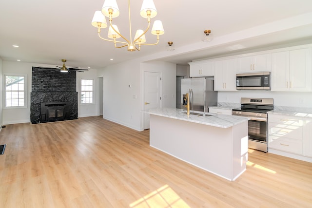 948 Meadow Ln, Lexington, KY 40505 - kitchen with a center island with sink, white cabinets, light wood-style floors, and appliances with stainless steel finishes