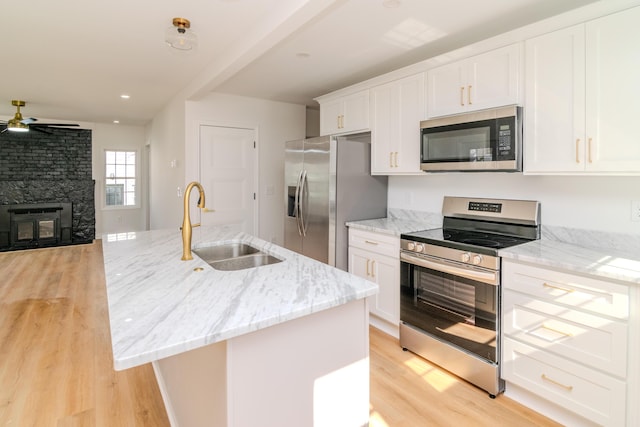 948 Meadow Ln, Lexington, KY 40505 - kitchen featuring a sink, a ceiling fan, light wood finished floors, appliances with stainless steel finishes, and white cabinets