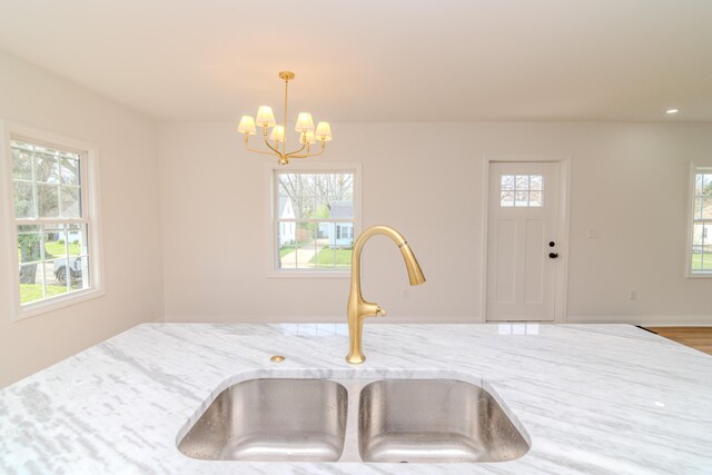 948 Meadow Ln, Lexington, KY 40505 - kitchen with pendant lighting, light stone countertops, a sink, and a chandelier