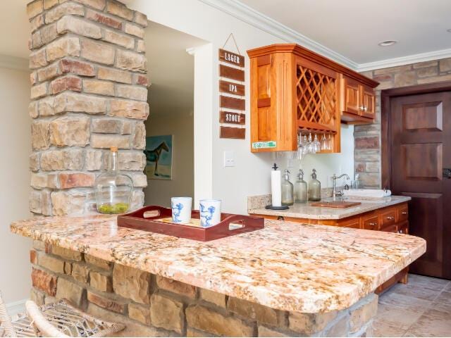 4950 Jennie Kate Ln, Lexington, KY 40510 - kitchen featuring brown cabinets, light stone counters, ornamental molding, and a sink