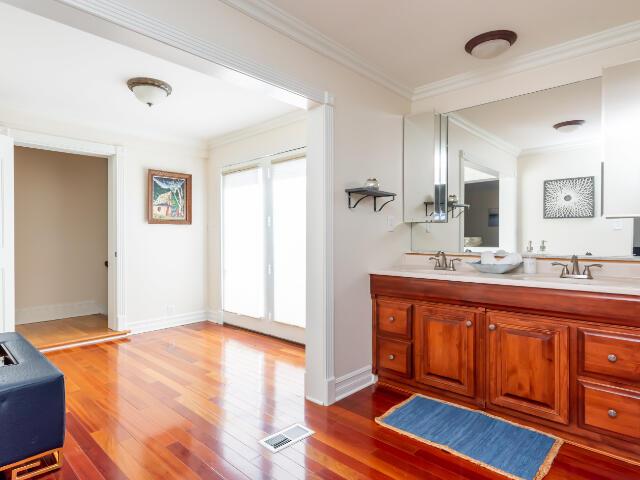 4950 Jennie Kate Ln, Lexington, KY 40510 - bathroom with wood finished floors, baseboards, visible vents, ornamental molding, and double vanity