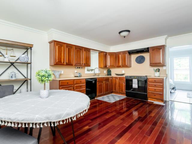 4950 Jennie Kate Ln, Lexington, KY 40510 - kitchen featuring range hood, black appliances, ornamental molding, and dark wood-style flooring
