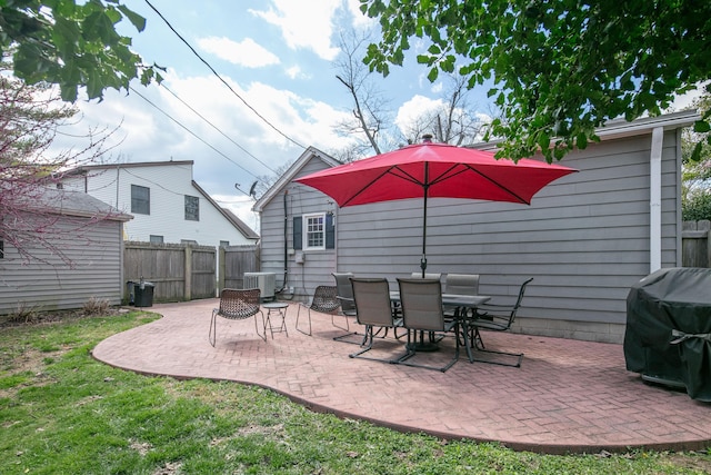 view of patio / terrace featuring a grill, fence, and central AC unit