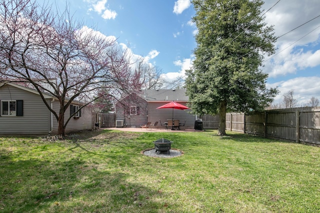 view of yard with a fenced backyard, an outdoor fire pit, and a patio