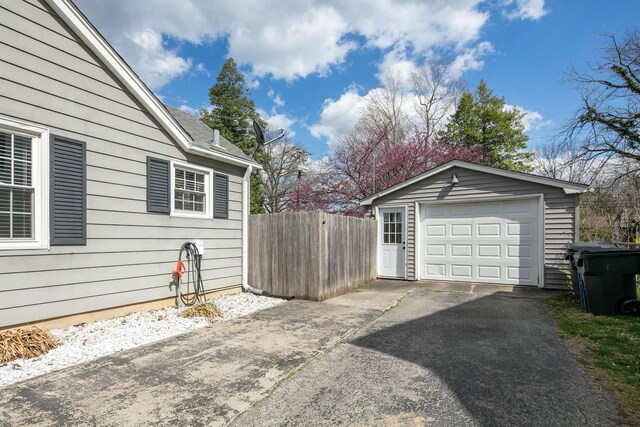 detached garage with driveway and fence