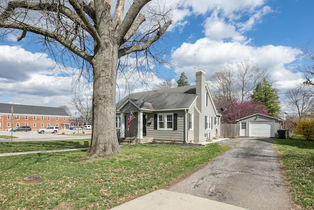 bungalow with driveway, a front yard, a chimney, an outdoor structure, and a garage