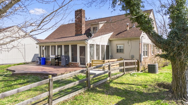 29 Quails Run Ln, West Liberty, KY 41472 - back of property featuring a sunroom, a patio area, a chimney, a shingled roof, and central AC