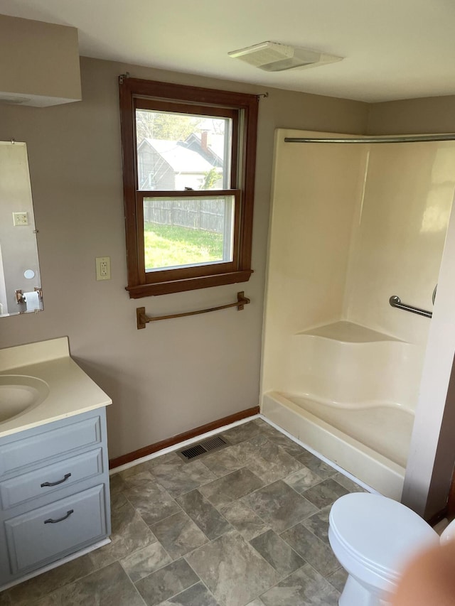 full bathroom with vanity, a shower, baseboards, toilet, and visible vents