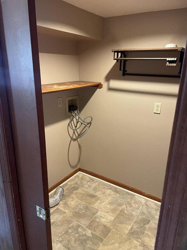 laundry area featuring washer hookup, stone finish flooring, baseboards, and laundry area