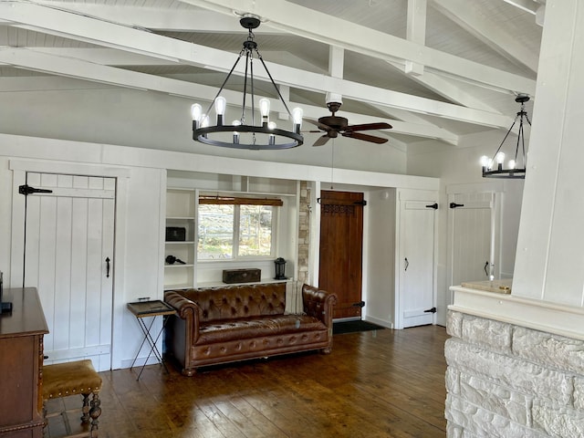 living area featuring dark wood-type flooring, vaulted ceiling with beams, and ceiling fan with notable chandelier