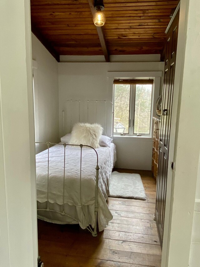 bedroom featuring wood ceiling, beam ceiling, and light wood-style floors