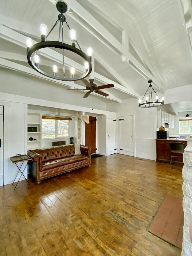 unfurnished living room with ceiling fan with notable chandelier, vaulted ceiling with beams, and hardwood / wood-style flooring