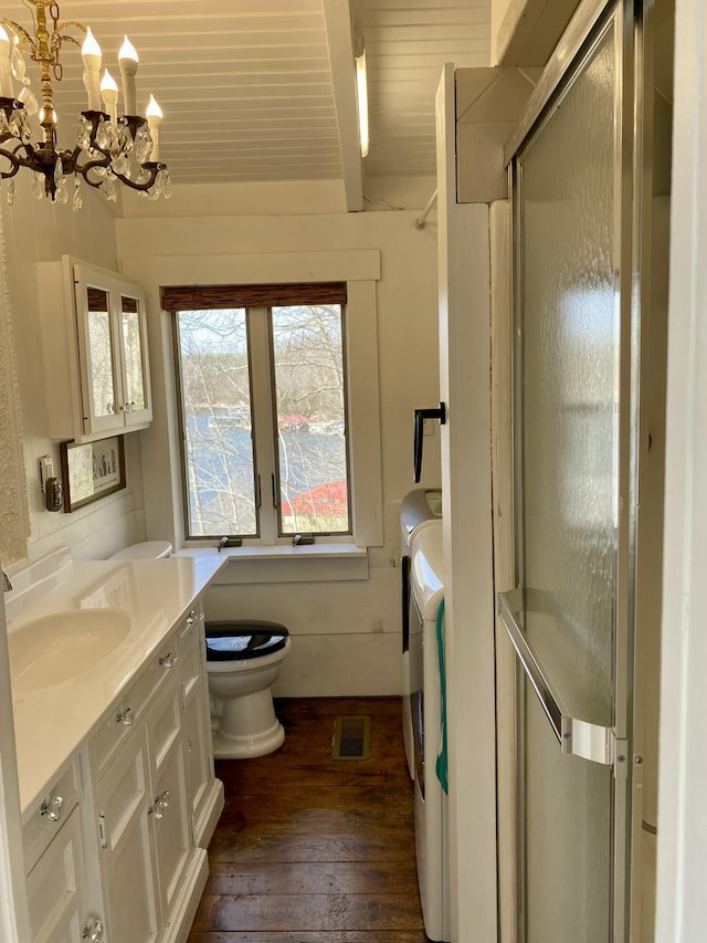 bathroom featuring visible vents, vanity, washer and clothes dryer, a notable chandelier, and wood-type flooring
