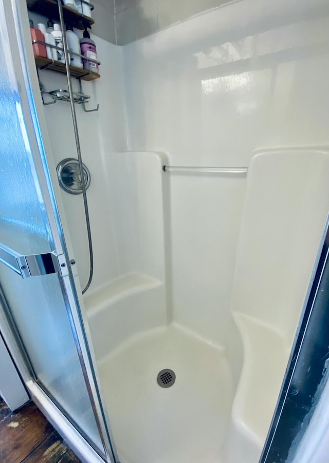 full bathroom featuring a stall shower and wood finished floors