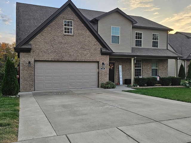 view of front of property with covered porch, brick siding, an attached garage, and driveway