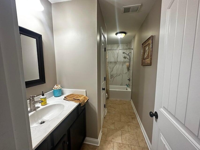 full bathroom featuring stone finish floor, visible vents, shower / washtub combination, vanity, and baseboards