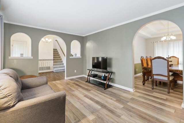 living room with light wood-style floors, stairway, baseboards, arched walkways, and an inviting chandelier