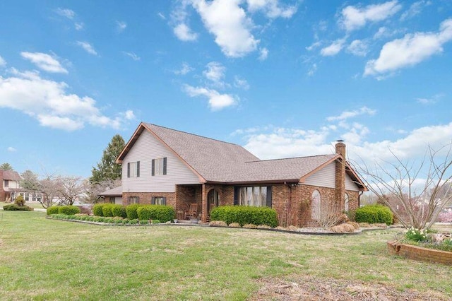 traditional-style house with a chimney, a front yard, and brick siding