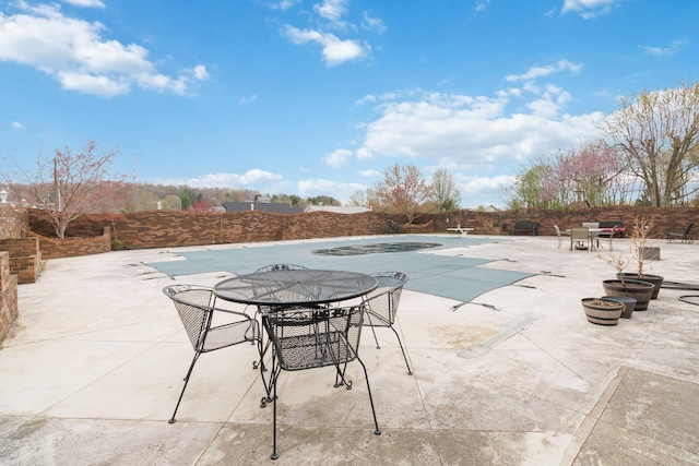 view of swimming pool with a fenced in pool, outdoor dining area, fence, and a patio