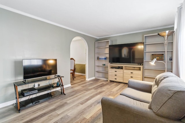 living area featuring arched walkways, ornamental molding, baseboards, and light wood finished floors