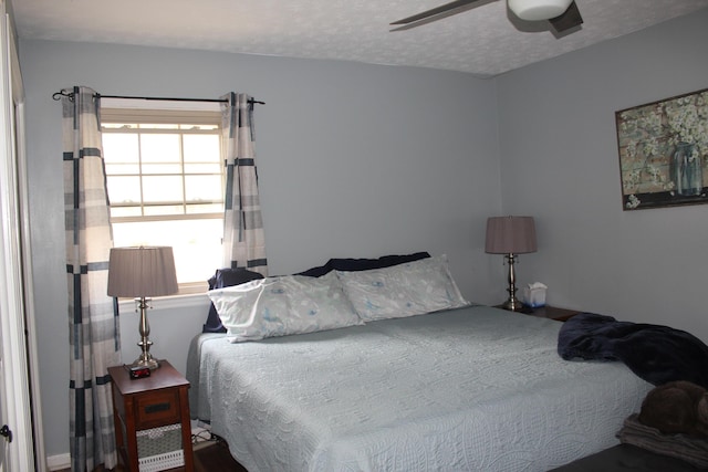 bedroom with a textured ceiling and a ceiling fan