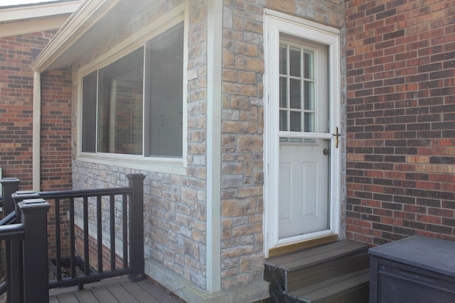 view of exterior entry featuring brick siding