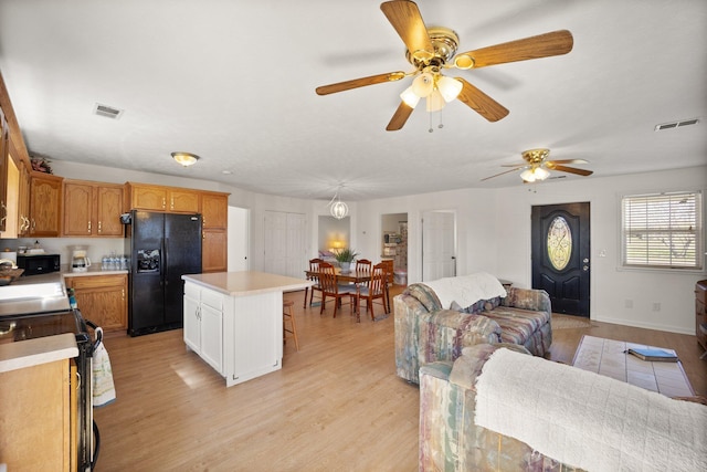 58 Mcclendon Ln, Russell Springs, KY 42642 - kitchen featuring black fridge, range with electric stovetop, open floor plan, light countertops, and light wood-type flooring