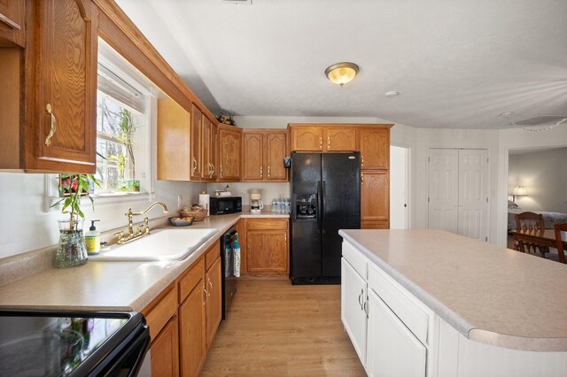 58 Mcclendon Ln, Russell Springs, KY 42642 - kitchen featuring black appliances, a sink, light countertops, light wood finished floors, and a center island